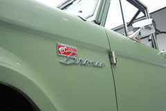Close-up of Classic Ford Bronco side badge with 'Sport Bronco' emblem on green body
