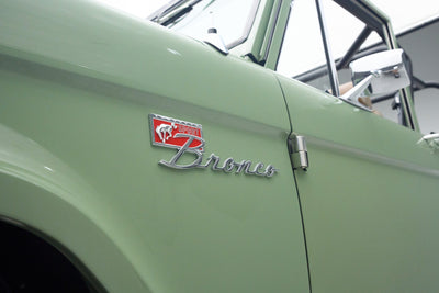 Close-up of Classic Ford Bronco side badge with 'Sport Bronco' emblem on green body