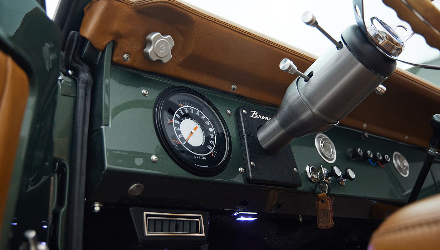 Dashboard gauges and steering column detail inside Classic Ford Bronco 1973 Highland Green