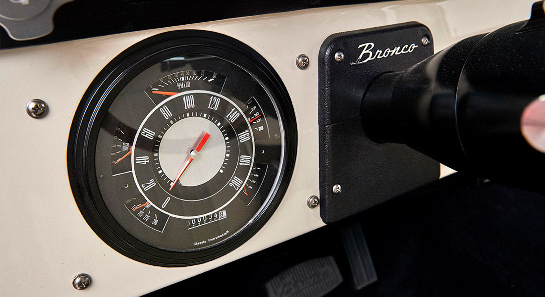 Classic Ford Bronco dashboard speedometer cluster with chrome trim and black background