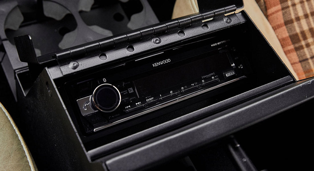 Kenwood stereo installed in a black center console compartment