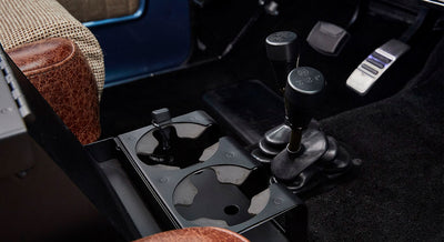Interior console area with cup holders and gear levers in a Classic Ford Bronco