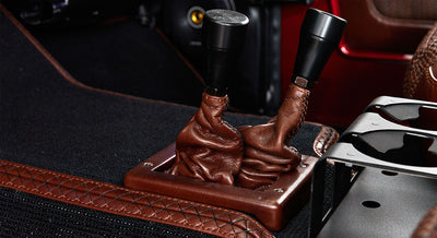 Two brown leather gear shifters in Classic Ford Bronco interior with black carpet
