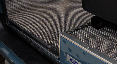 Woven custom carpet with a Ford logo at the vehicle door sill