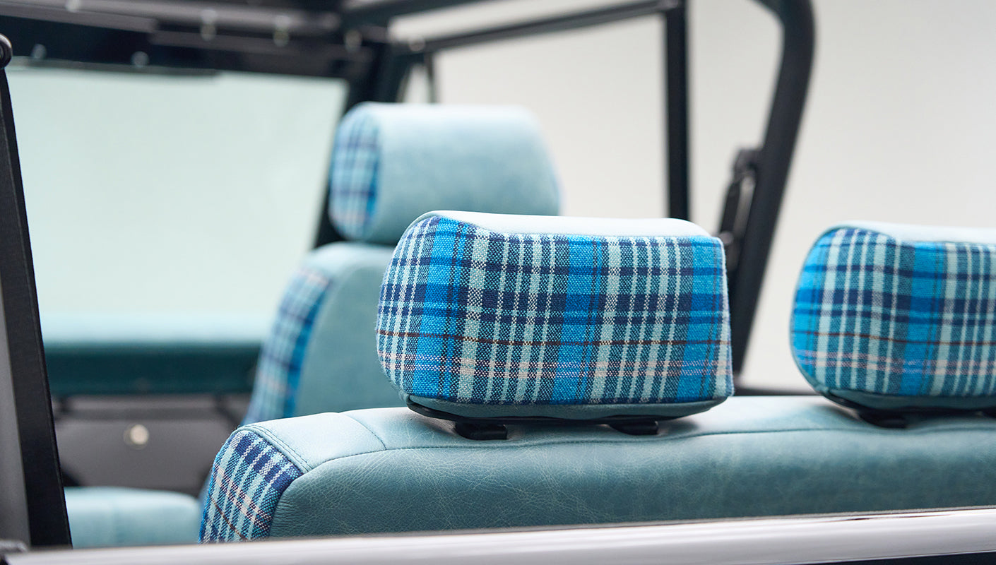 Rear headrests with teal leather and blue plaid fabric in Classic Ford Bronco interior