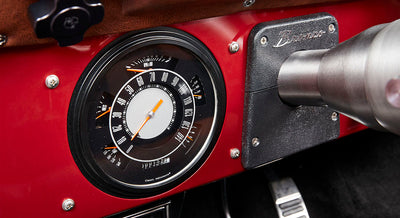 Classic Ford Bronco dashboard speedometer with black and white dial and orange needle