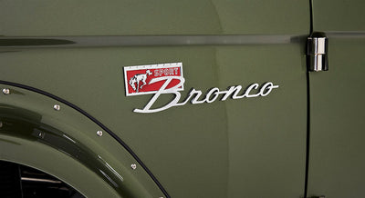 Classic Ford Bronco Sport badge on olive green vehicle body near door hinge and black fender flare