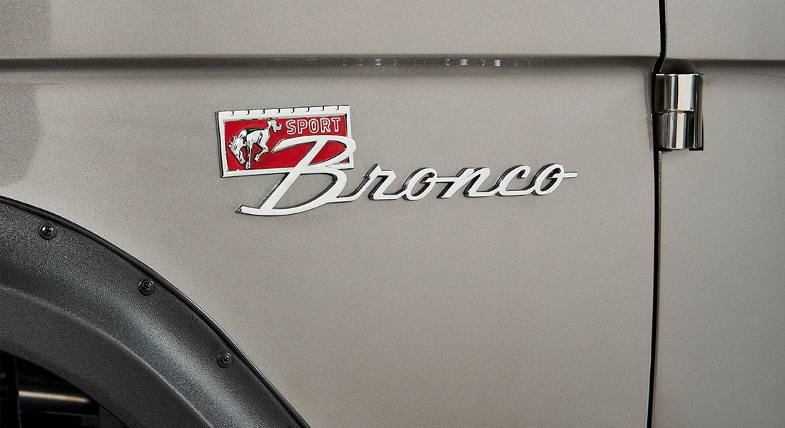 Classic Ford Bronco Sport badge on beige vehicle body near door hinge and black fender flare