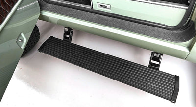 Extendable black doorstep attached to entry of green door on Classic Ford Bronco
