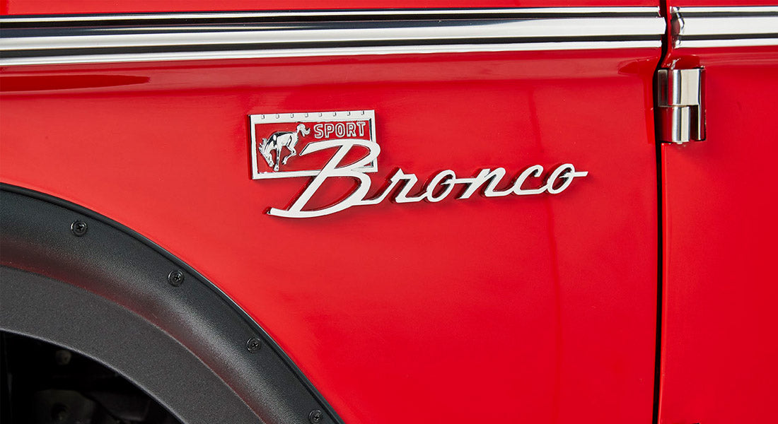 Red Classic Ford Bronco Sport emblem on vehicle door with black fender