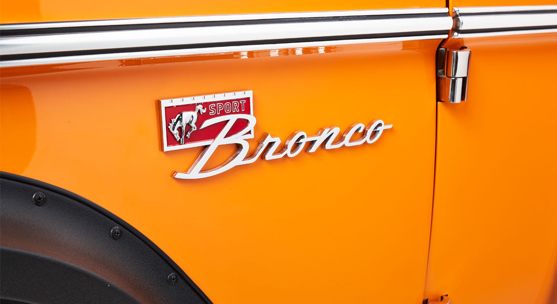 Orange Classic Ford Bronco side panel with Sport Bronco emblem
