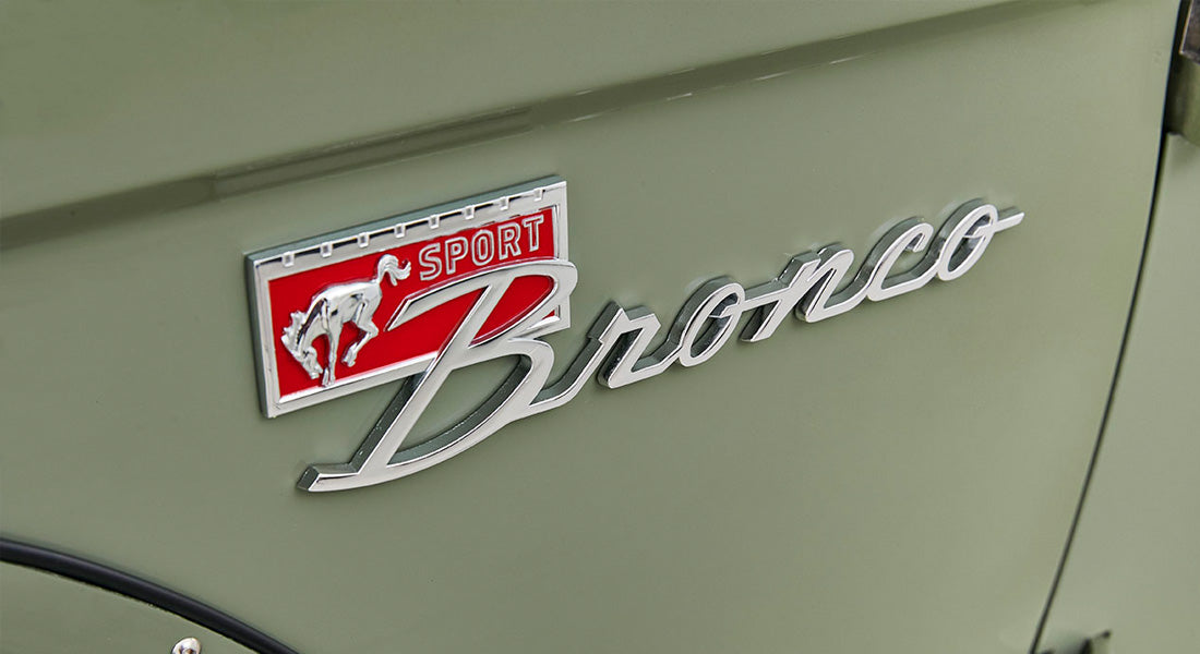 Close-up of red SPORT Bronco emblem on light green Classic Ford Bronco door