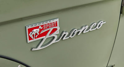 Close-up of red SPORT Bronco emblem on light green Classic Ford Bronco door