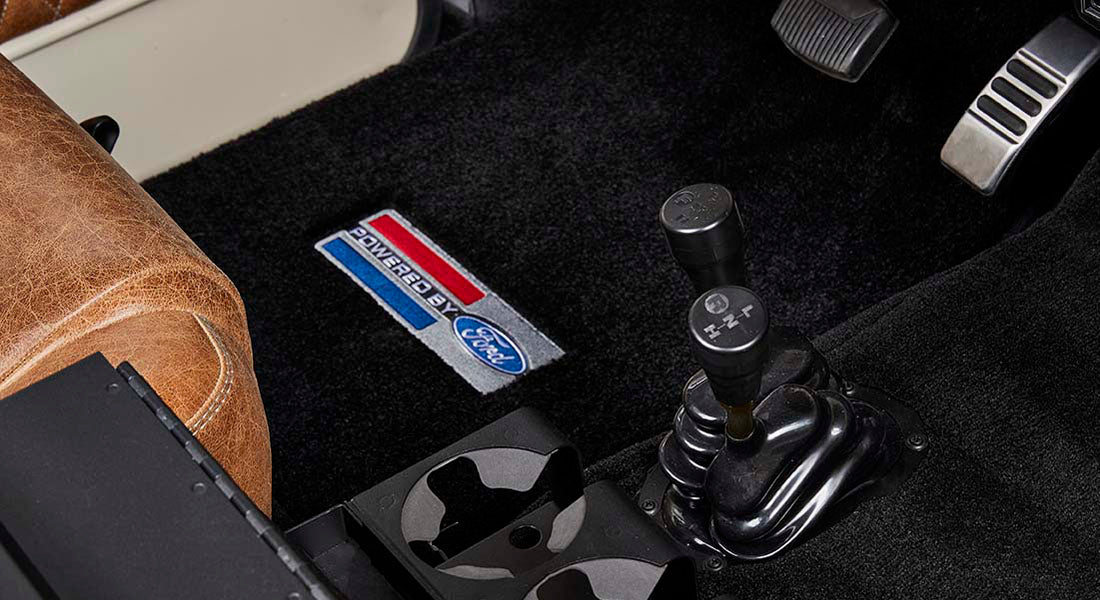 Floor area with gear shifter and transfer case levers and Ford badge on Classic Ford Bronco