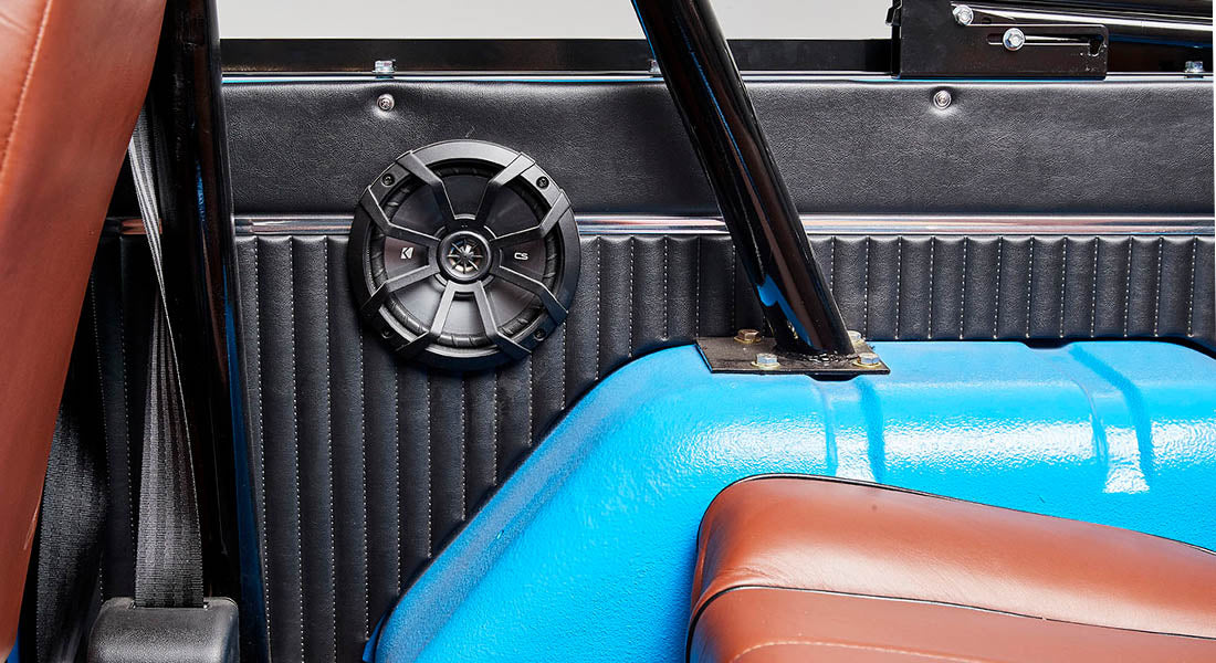 Black speaker mounted inside with blue and brown interior elements of a Classic Ford Bronco