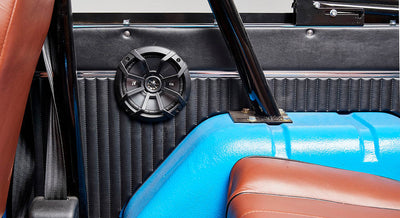 Black speaker mounted inside with blue and brown interior elements of a Classic Ford Bronco
