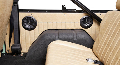 Interior side panel of Classic Ford Bronco with dual black speakers and beige leather upholstery.