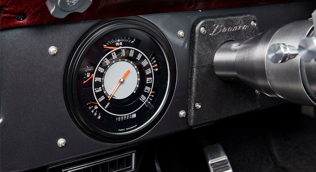 Speedometer and rpm gauge on the dashboard of a Classic Ford Bronco with black and silver detailing.