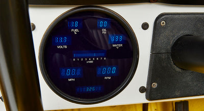 Round vehicle gauge cluster with digital blue display showing fuel, oil, volts, water, speed, and RPM