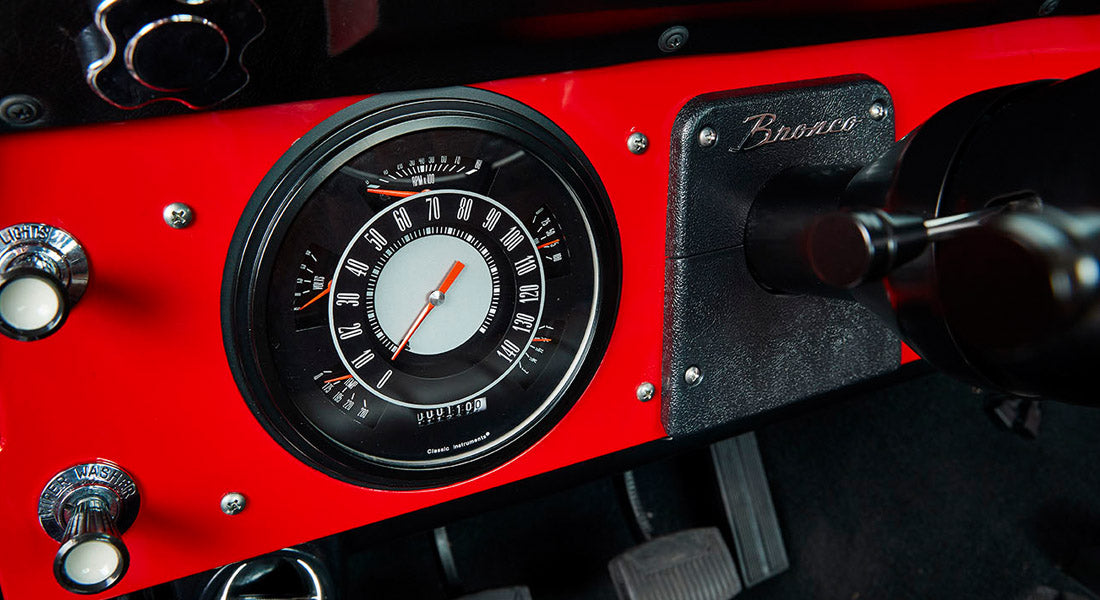 Red Classic Ford Bronco dashboard speedometer and ignition key inserted