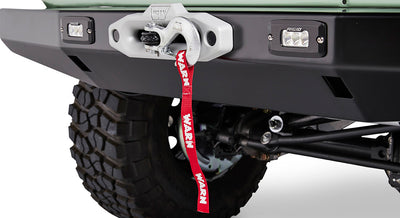 Front bumper of Classic Ford Bronco equipped with a Warn winch and two off-road lights.
