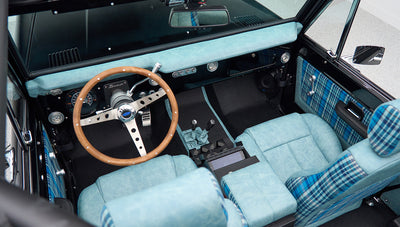 Overhead view of Classic Ford Bronco interior with wooden steering wheel and blue plaid seats