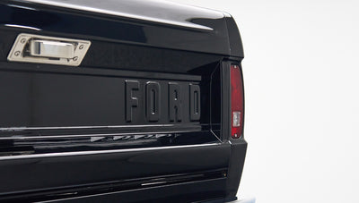 Close-up of black tailgate on Classic Ford Bronco with large embossed FORD lettering