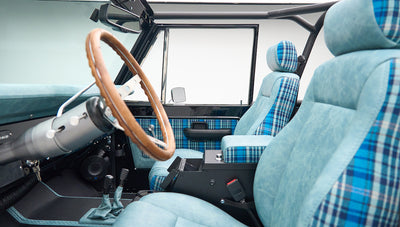 Classic Ford Bronco interior side view with open door and blue plaid seats