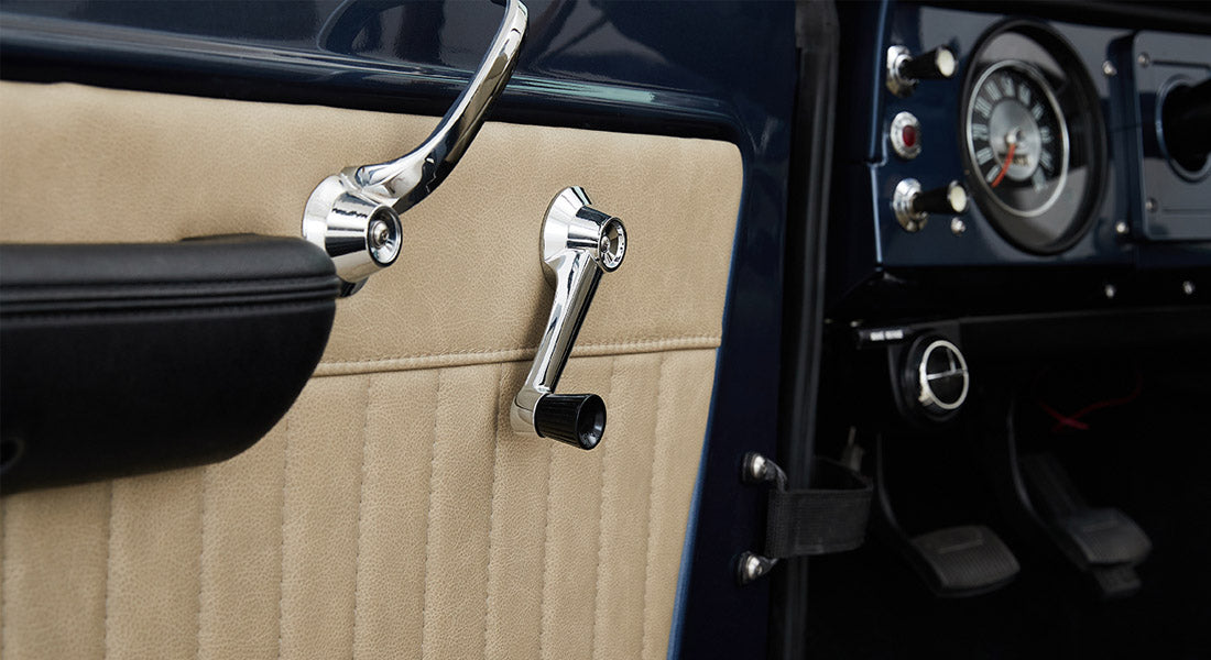 Interior door panel detail of Classic Ford Bronco with beige panel and chrome handles
