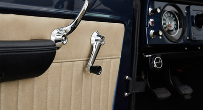 Interior door panel detail of Classic Ford Bronco with beige panel and chrome handles