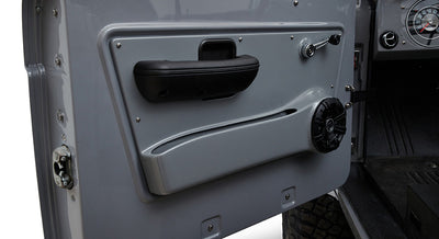 Interior side of Classic Ford Bronco door with black speaker, door handle and grey panel
