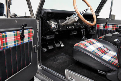 Classic Ford Bronco interior door panel with plaid fabric and manual window crank