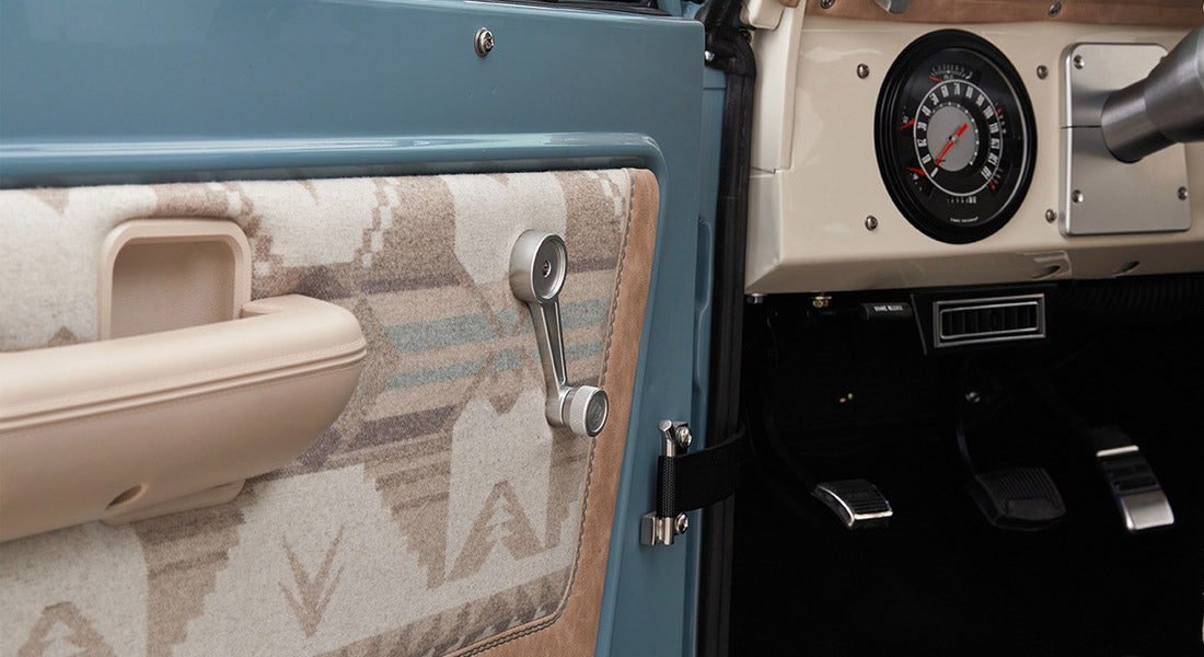 Classic Ford Bronco door interior panel with fabric insert and manual window crank