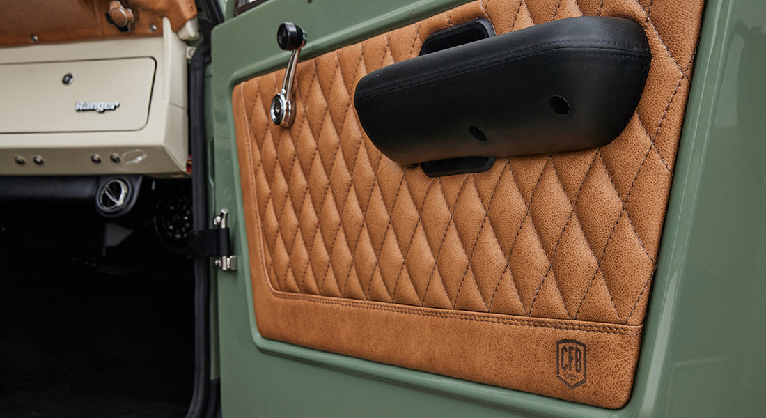 Quilted tan leather door panel with black armrest and Ford Bronco Ranger branding