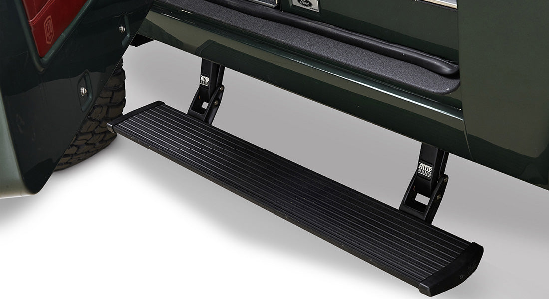 Black retractable door step extending from a dark green vehicle door