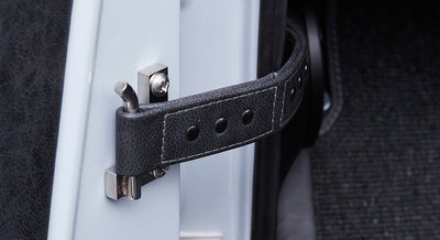 Vehicle door strap made from black stitched material attached to painted door frame