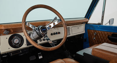 1976 Blue Classic Ford Bronco Coyote Series with black soft top and whiskey leather interior