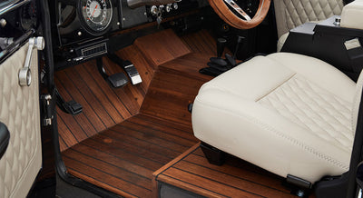 Interior floorboard with wood-like finish and quilted white leather seat with visible pedals