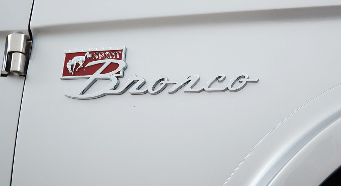 Chrome Sport Bronco emblem on white vehicle body panel