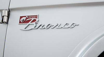 Chrome Sport Bronco emblem on white vehicle body panel