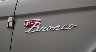 Chrome Sport Bronco emblem on the side panel of a gray vehicle