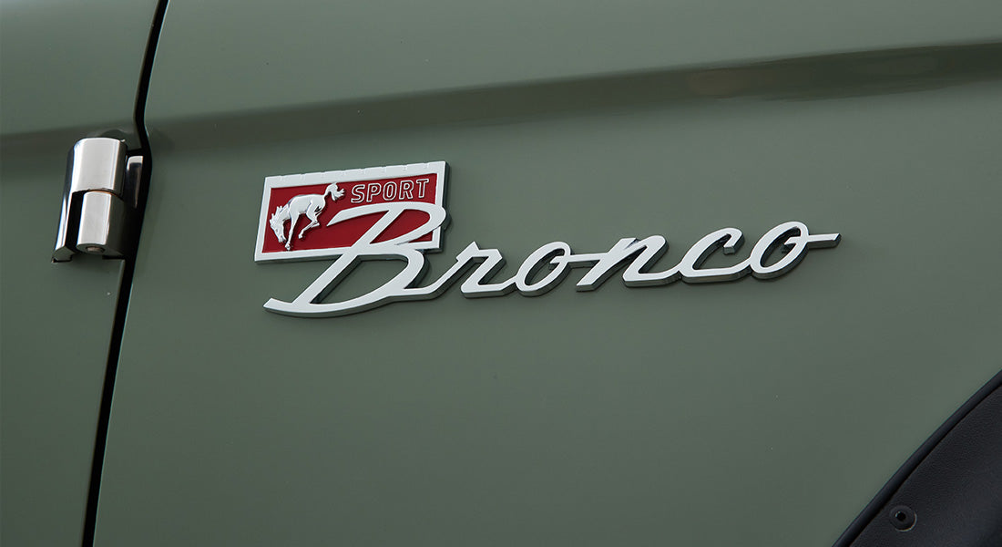Classic Ford Bronco emblem with red 'Sport' badge on green vehicle exterior