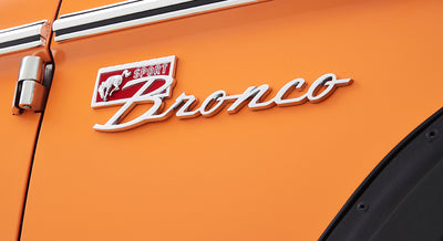Classic Ford Bronco Sport emblem mounted on orange vehicle door