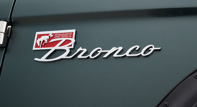 Classic Ford Bronco logo badge on dark green vehicle exterior