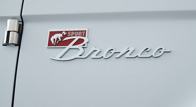 Chrome Classic Ford Bronco Sport emblem on light gray vehicle body