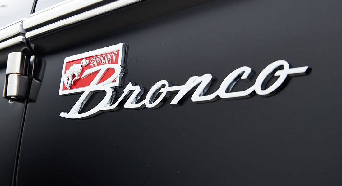 Close-up of Classic Ford Bronco emblem on black exterior door panel