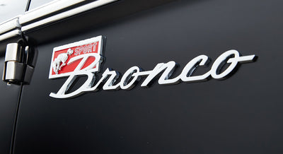Close-up of Classic Ford Bronco emblem on black exterior door panel