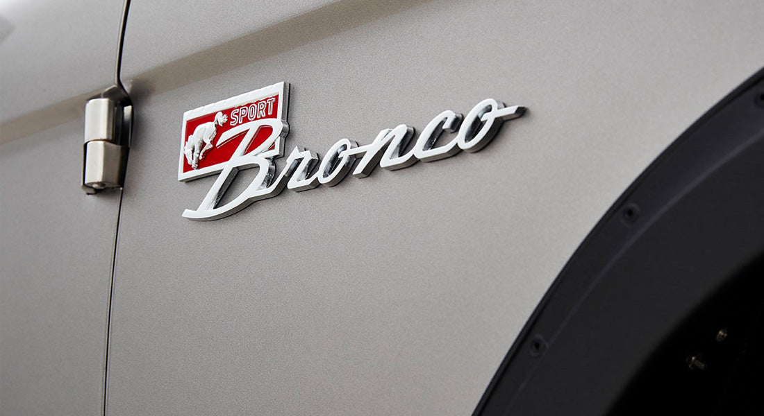 Close-up of Classic Ford Bronco emblem on gray vehicle body