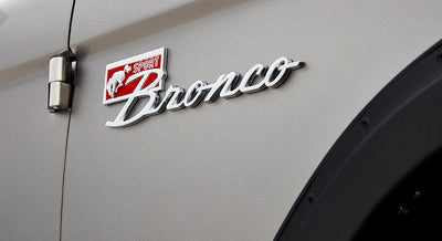 Close-up of Classic Ford Bronco emblem on gray vehicle body
