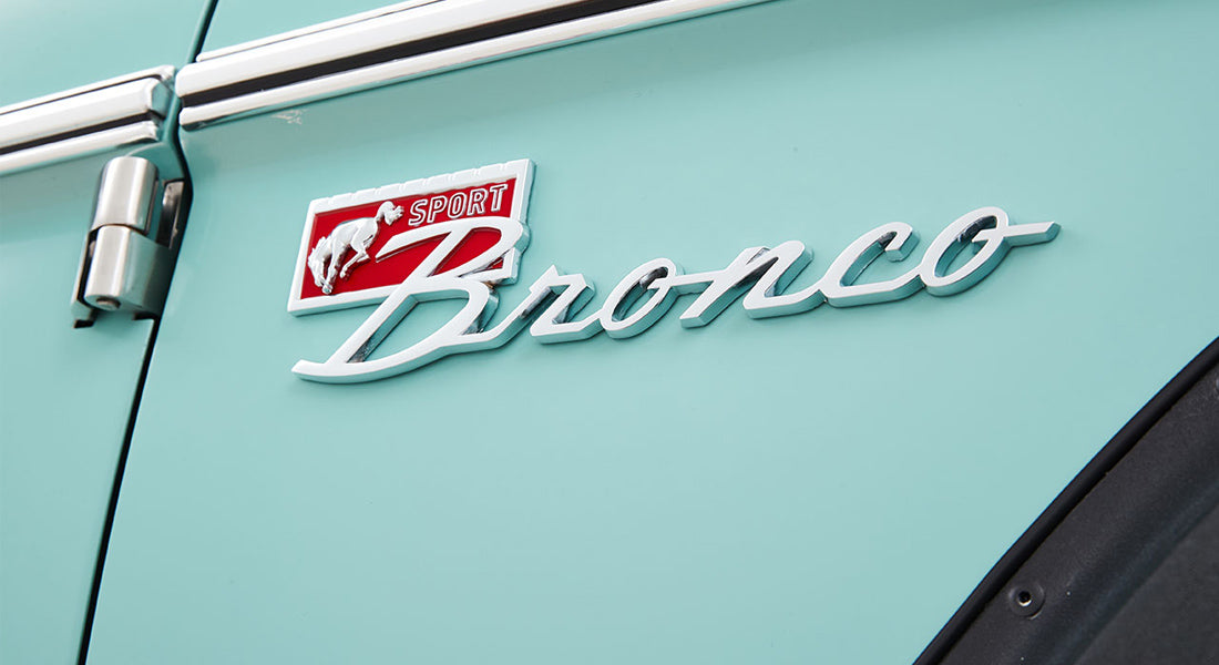 Classic Ford Bronco emblem on turquoise vehicle door panel